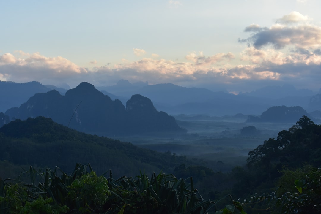Misty mountains near Chiang Mai at sunrise with layers of green hills fading into the distance