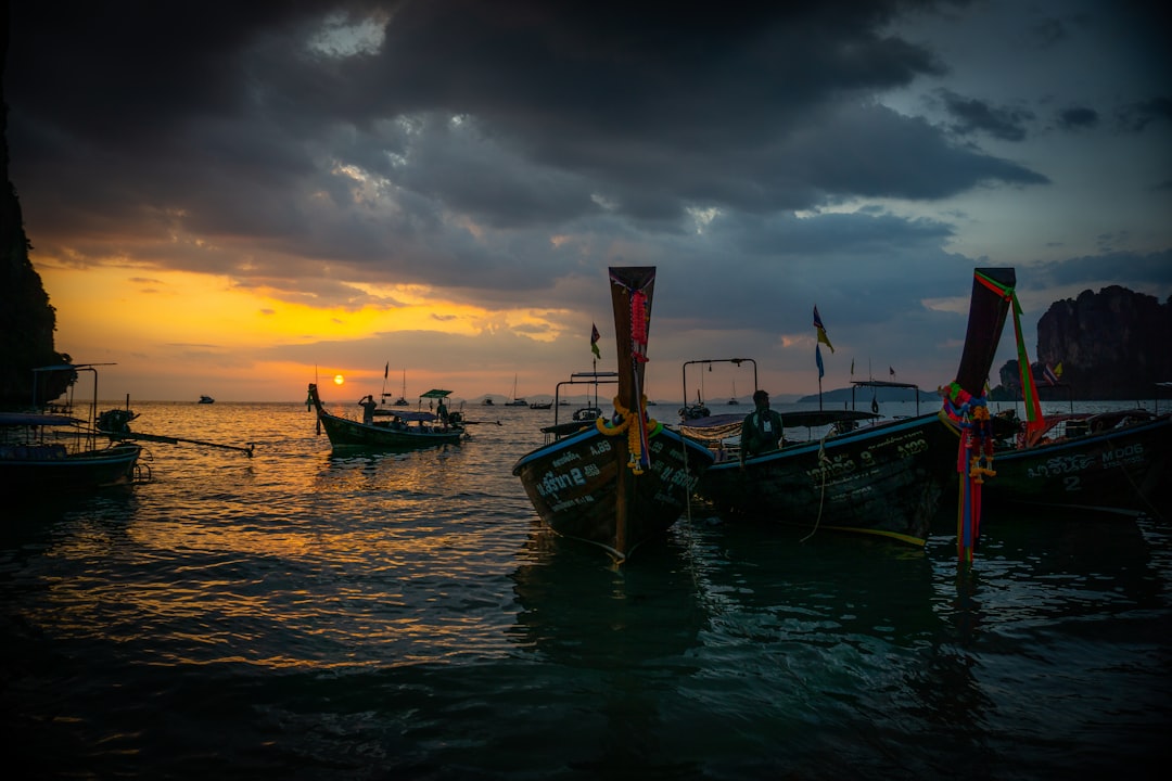 Sunset over the Andaman Sea from Promthep Cape, Phuket, with silhouettes of longtail boats