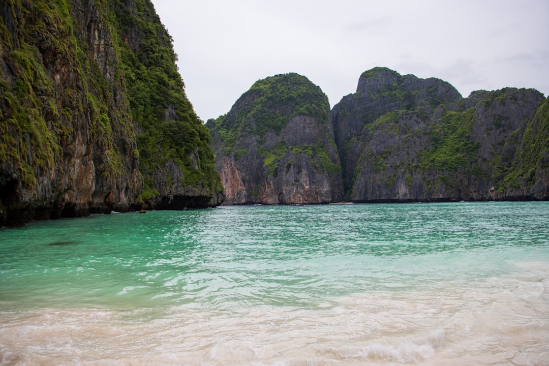 Crystal clear water at a secluded Phuket beach with limestone rocks and tropical vegetation