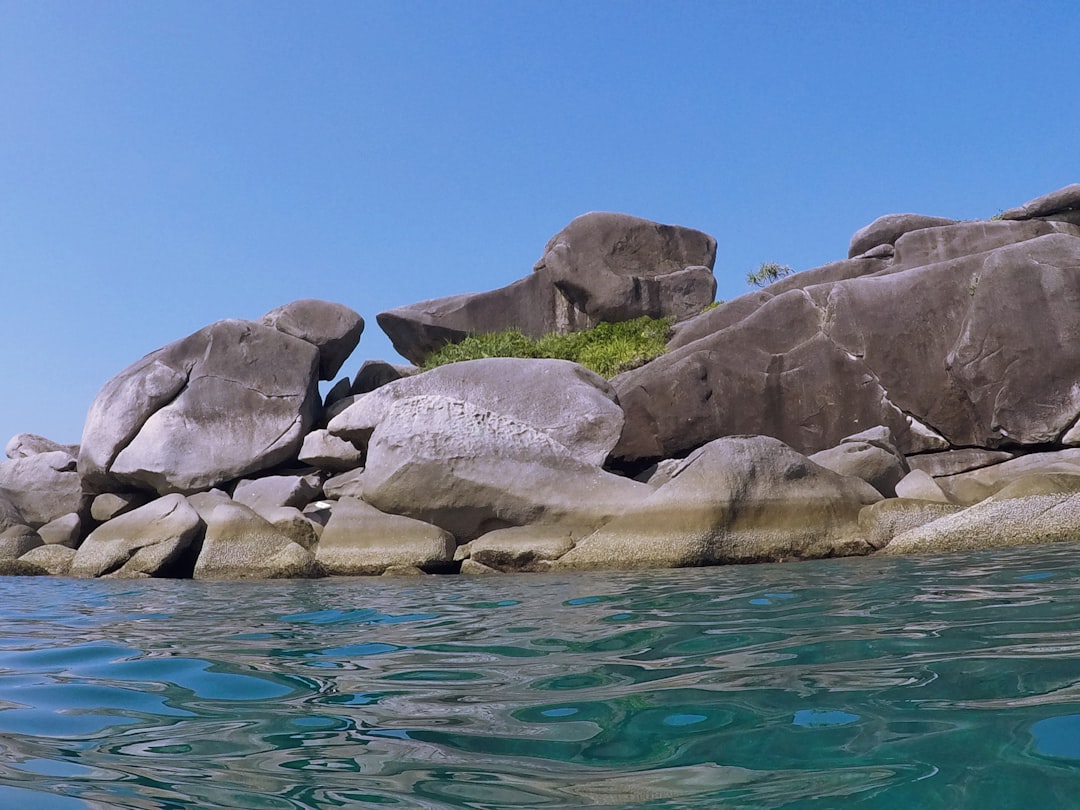Crystal clear turquoise water around the Similan Islands with white sand beach and granite boulders